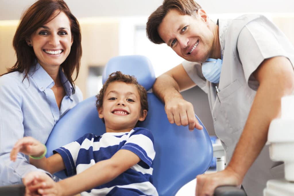 Smiling child receiving dental sealants at dentist, concept of cavity prevention and pediatric oral care.