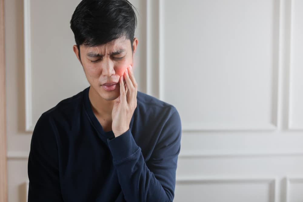Man experiencing toothache in need of emergency dentistry in Calgary, AB