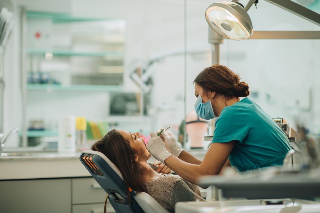 Dental professional examining a patient’s teeth to assess tooth damage and restorative treatment needs.