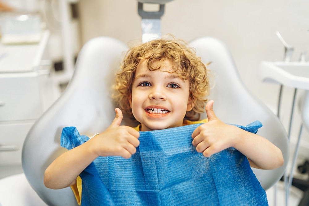 Young child giving tumbs up at his dentist appointment in Calgary